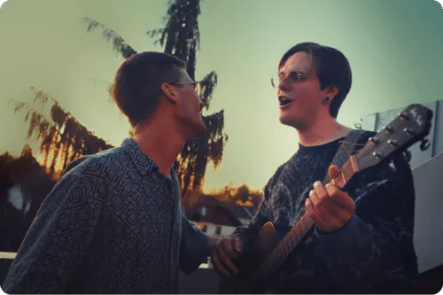 Zwei Musiker singen gemeinsam mit Gitarre