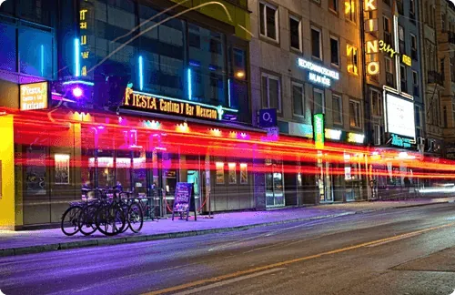 Leuchtreklamen und Lichtspuren in der Münchner Innenstadt bei Nacht