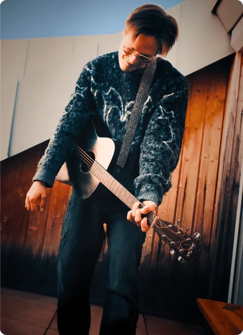 Gitarrist bei einer Session vor Holzwand