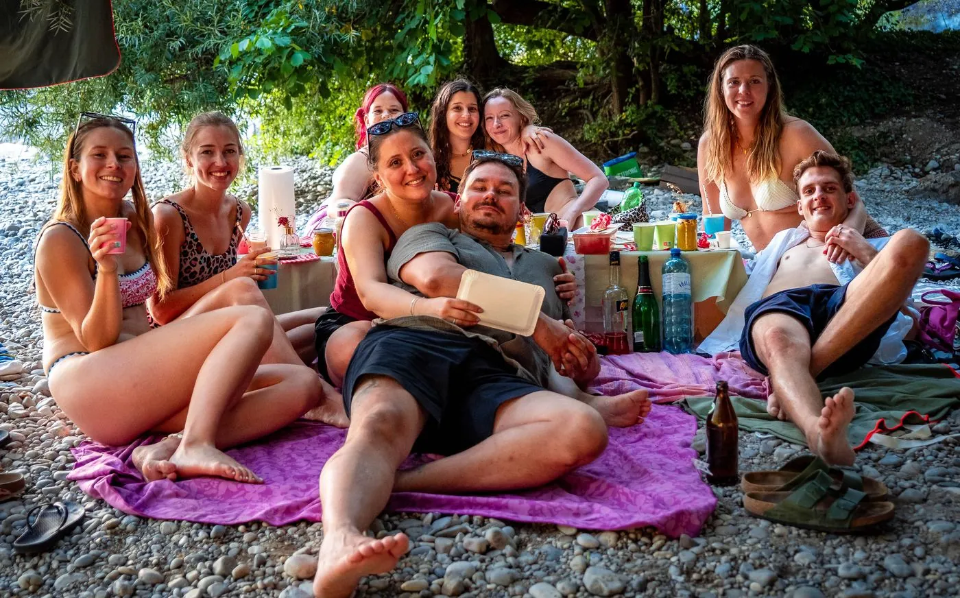 Freunde feiern auf einer Picknickdecke am Flaucher