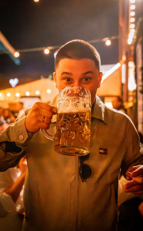 Mann trinkt aus einer frischen Maß