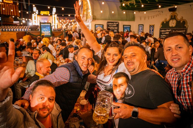 Feiernde Gruppe im vollen Festzelt mit erhobenen Händen