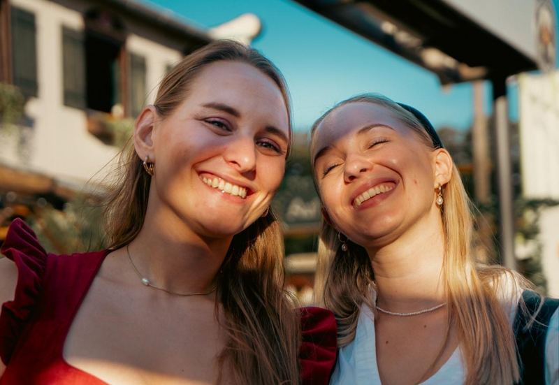 Zwei Freundinnen im Dirndl lächeln in der Sonne