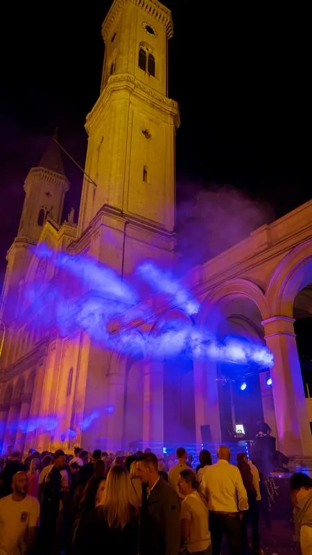 Blaue Laserstrahlen über dem Publikum vor der Kirche